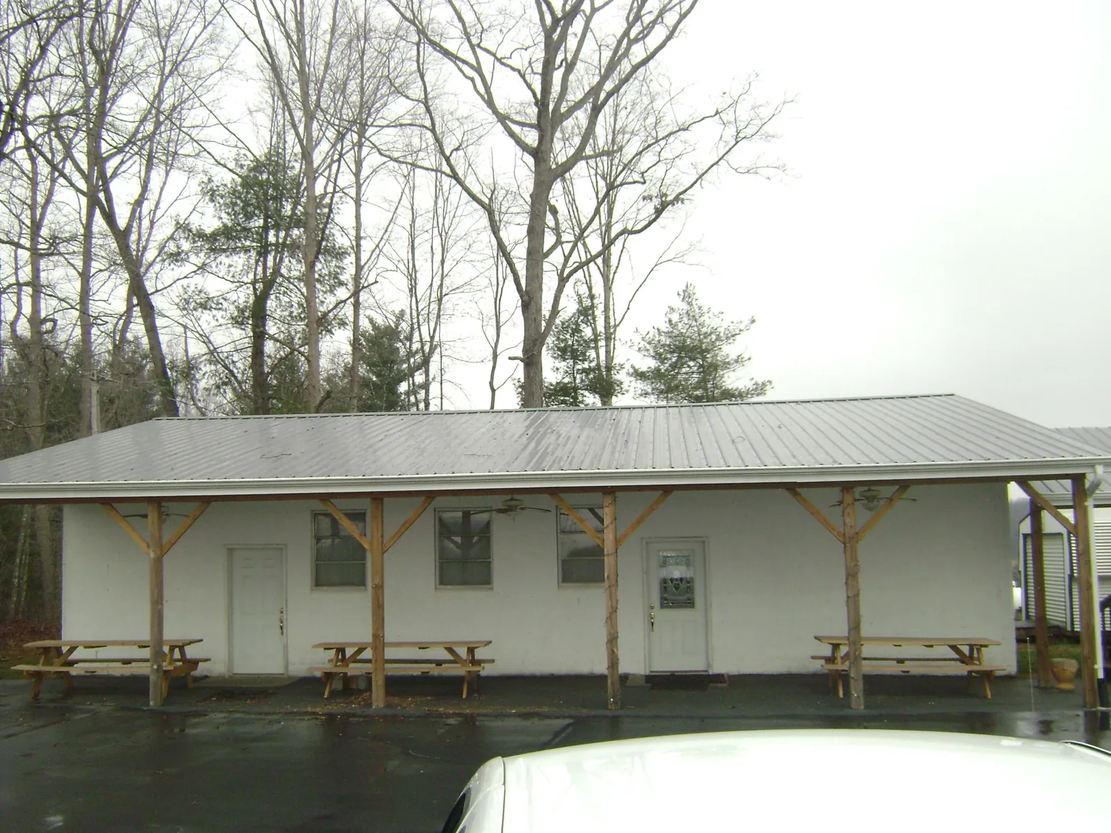 Gray metal roof over a block building with a timber post porch in Cooke City